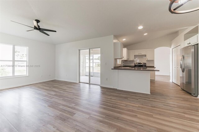 kitchen with appliances with stainless steel finishes, sink, white cabinets, ceiling fan, and kitchen peninsula