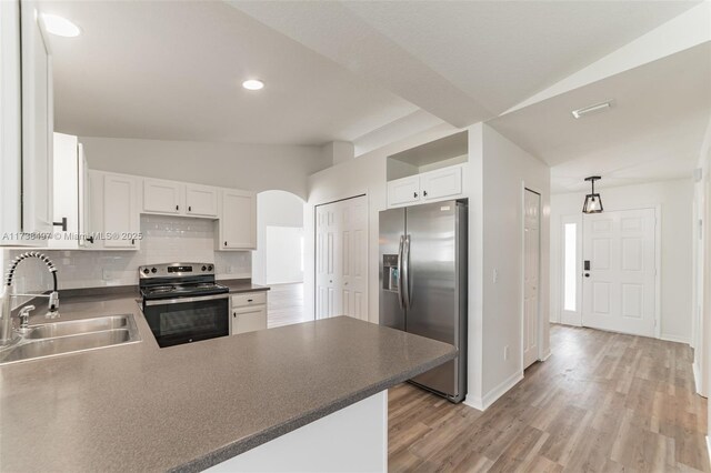 kitchen with sink, stainless steel appliances, kitchen peninsula, and white cabinets