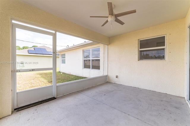 unfurnished sunroom featuring a wealth of natural light and a ceiling fan