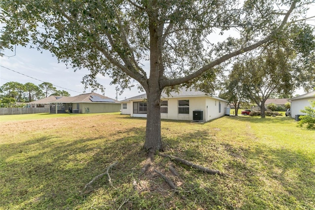 view of yard with central AC unit and fence