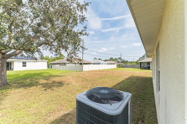 view of yard featuring fence and central air condition unit