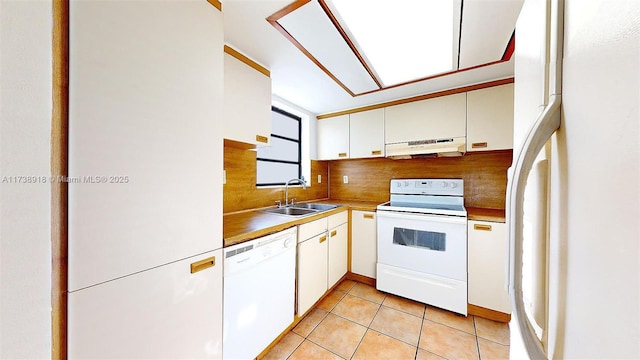 kitchen featuring light tile patterned flooring, sink, backsplash, white cabinets, and white appliances