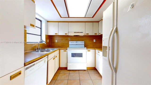 kitchen featuring sink, white appliances, tasteful backsplash, white cabinets, and light tile patterned flooring