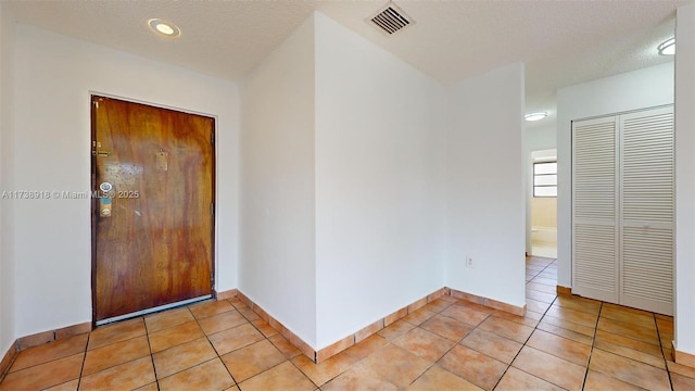 tiled foyer featuring a textured ceiling