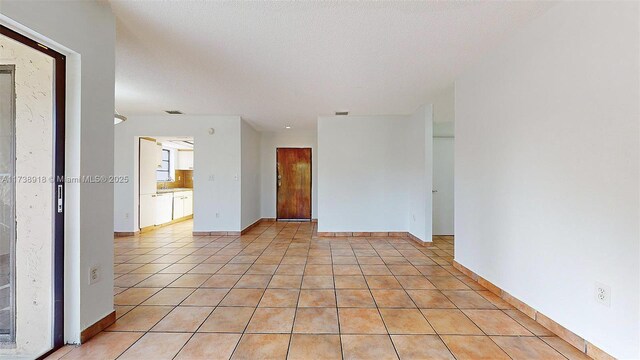 tiled empty room with a textured ceiling