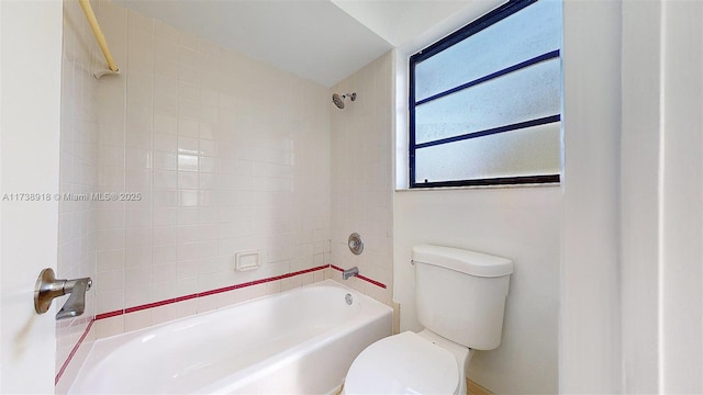 bathroom featuring tiled shower / bath and toilet