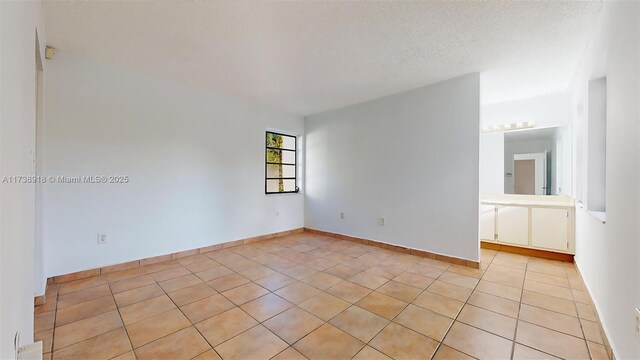 tiled empty room with a textured ceiling