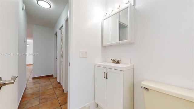 bathroom with vanity, tile patterned flooring, and toilet