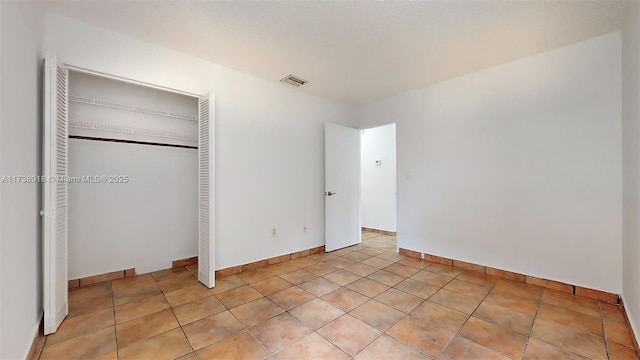 unfurnished bedroom featuring a closet and light tile patterned floors