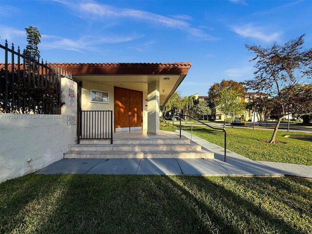 doorway to property with a lawn