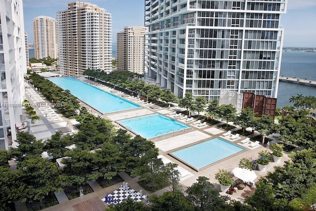 view of pool with a water view and a patio