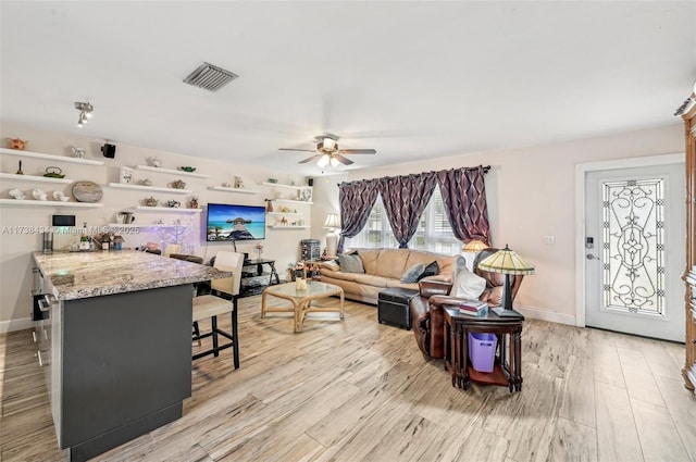 living room featuring light hardwood / wood-style flooring and ceiling fan