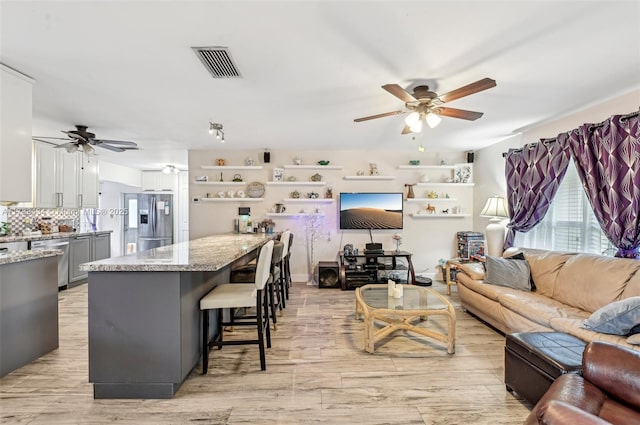 living room with ceiling fan and light hardwood / wood-style floors