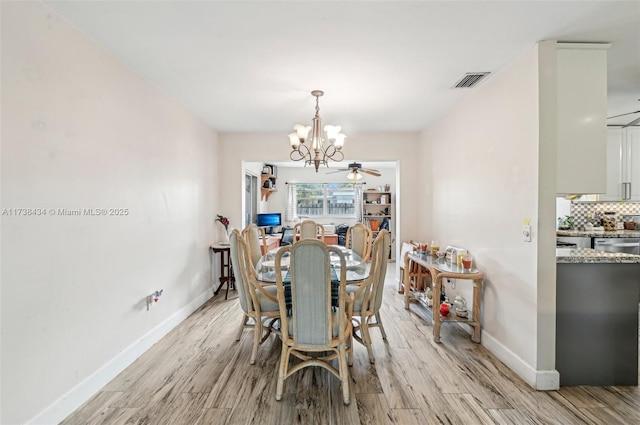 dining space featuring ceiling fan with notable chandelier and light hardwood / wood-style flooring