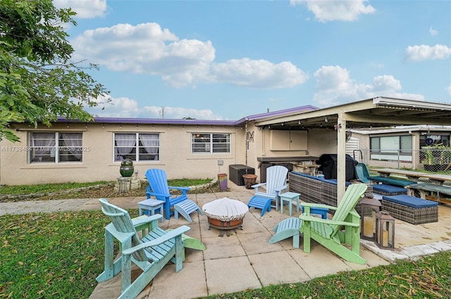 back of house featuring a patio area and a fire pit