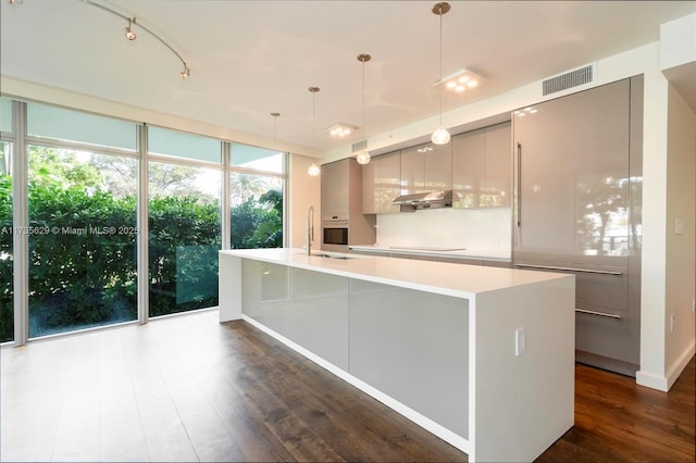 kitchen with gray cabinetry, hanging light fixtures, a spacious island, and black electric stovetop