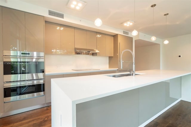 kitchen with sink, decorative light fixtures, dark wood-type flooring, and stainless steel double oven