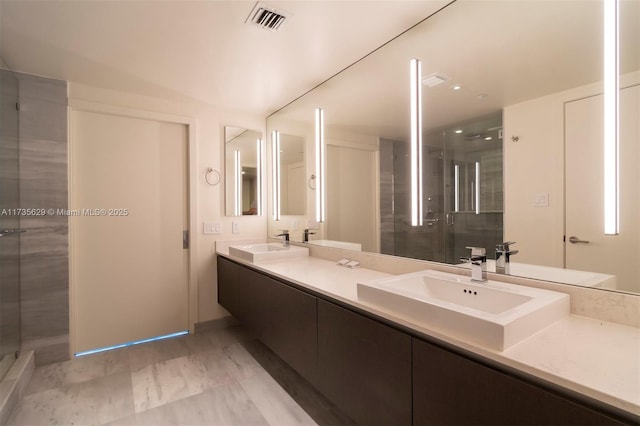 bathroom with vanity and a tile shower