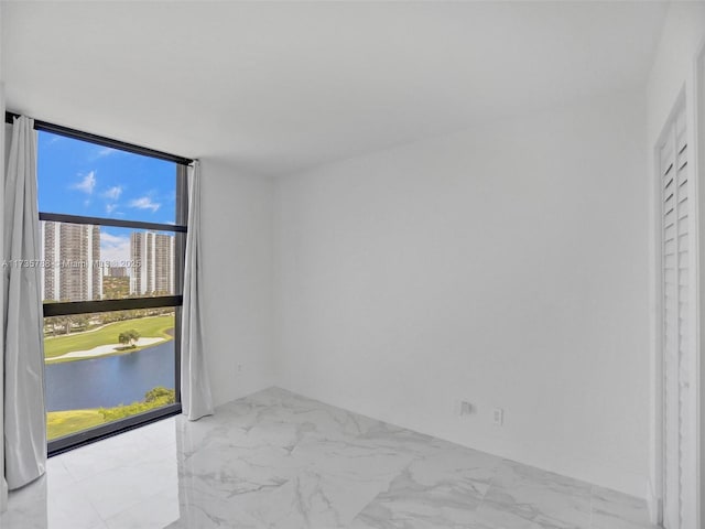 empty room featuring expansive windows and a water view