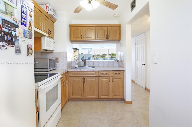 kitchen with sink, white appliances, light tile patterned floors, ceiling fan, and backsplash