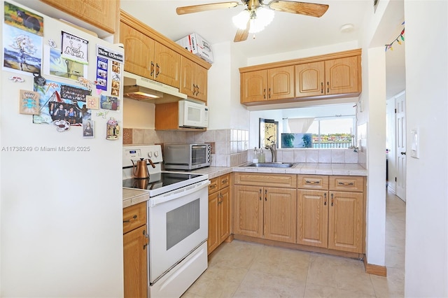 kitchen with sink, tasteful backsplash, tile countertops, ceiling fan, and white appliances