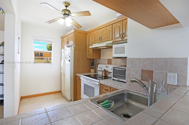 kitchen featuring sink, white appliances, ceiling fan, decorative backsplash, and tile countertops