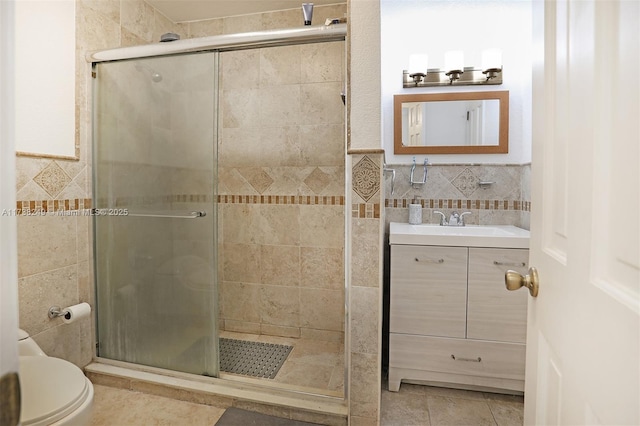 bathroom with vanity, an enclosed shower, tile walls, and toilet