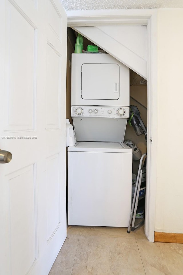 washroom with stacked washing maching and dryer