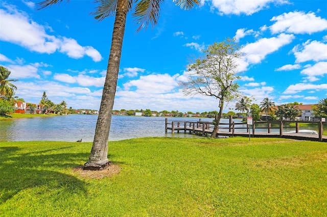 dock area with a water view and a lawn