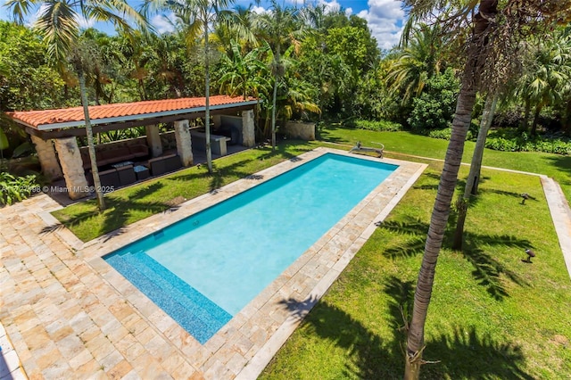 outdoor pool with a patio and a lawn