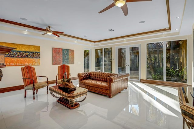 living area with visible vents, ornamental molding, a ceiling fan, a tray ceiling, and french doors