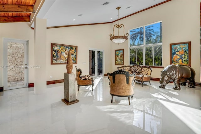 interior space with visible vents, crown molding, baseboards, beamed ceiling, and a towering ceiling