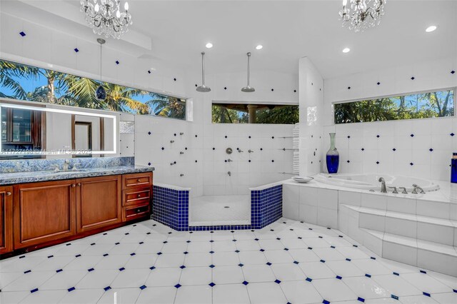 bathroom with independent shower and bath, sink, and a notable chandelier