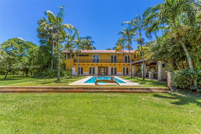 back of house with a lawn, french doors, an outdoor pool, a balcony, and a patio area