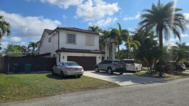 mediterranean / spanish-style home with a garage and a front lawn