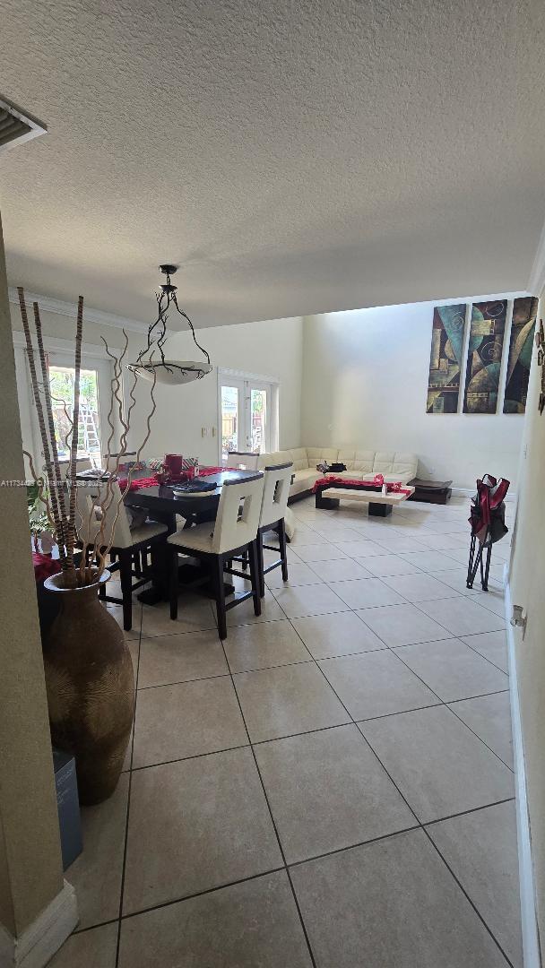 tiled dining space with a wealth of natural light and a textured ceiling