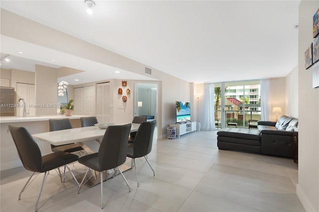 dining space featuring floor to ceiling windows and sink