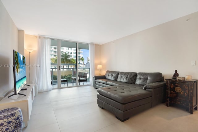 living room featuring a wall of windows and light tile patterned floors