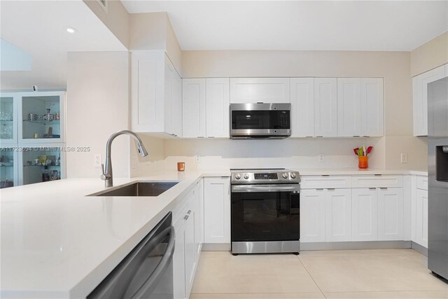 1155 Brickell Bay Dr Unit 704, Miami, FL 33131 - kitchen featuring stainless steel appliances, a sink, white cabinetry, light countertops, and a peninsula