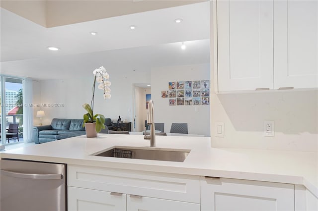 kitchen featuring dishwasher, sink, and white cabinets