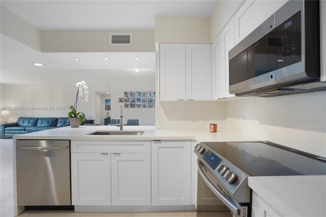 1155 Brickell Bay Dr Unit 704, Miami, FL 33131 - kitchen with appliances with stainless steel finishes, a sink, open floor plan, white cabinetry, and recessed lighting