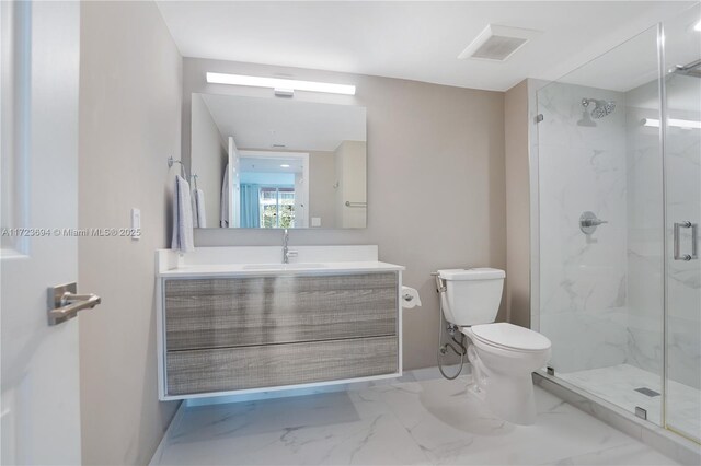 bathroom with vanity, a shower with door, and toilet