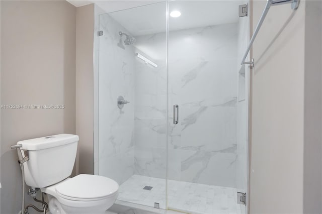 bathroom with toilet and a shower with shower door