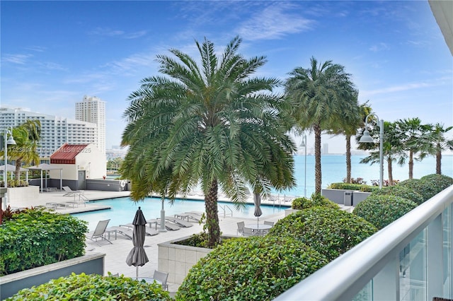 view of pool featuring a patio and a water view