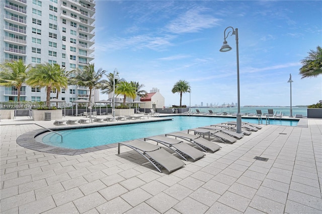 view of pool featuring a patio and a water view