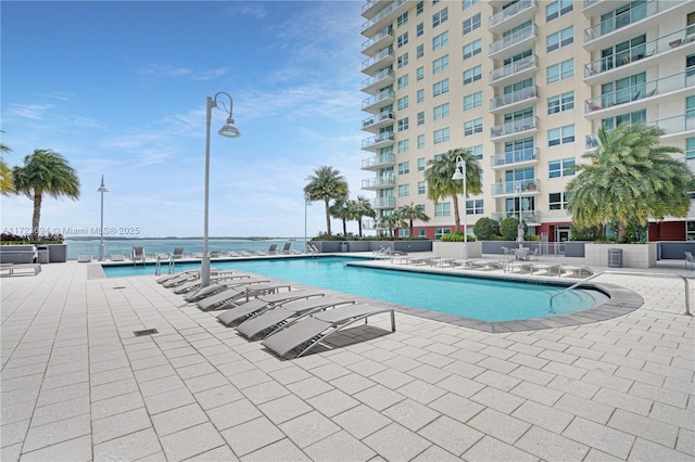 view of pool with a patio area and a water view