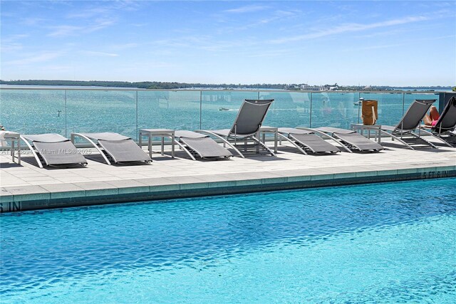 view of swimming pool with a water view