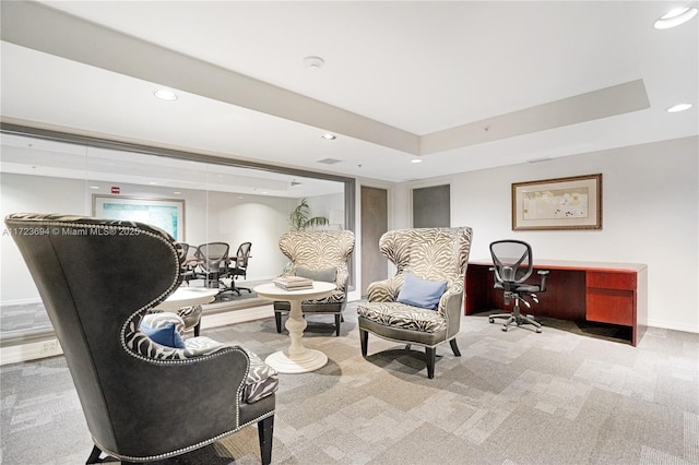 sitting room featuring carpet flooring and a raised ceiling