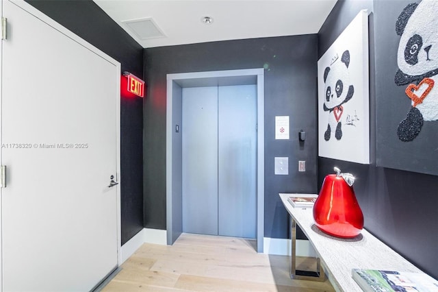 interior space featuring wood-type flooring and elevator