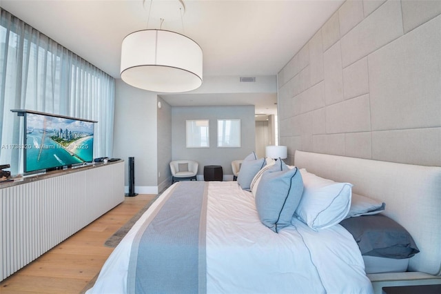 bedroom featuring tile walls and light hardwood / wood-style floors